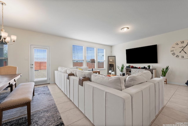 tiled living room featuring a wealth of natural light and an inviting chandelier