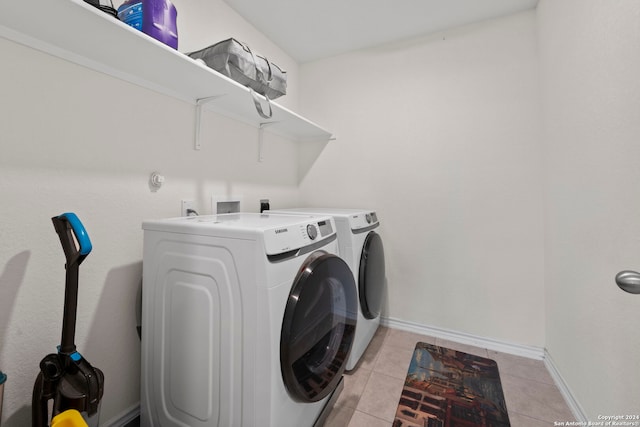 laundry area with washer and dryer and light tile patterned floors