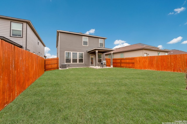 back of house with a lawn, a patio area, and cooling unit