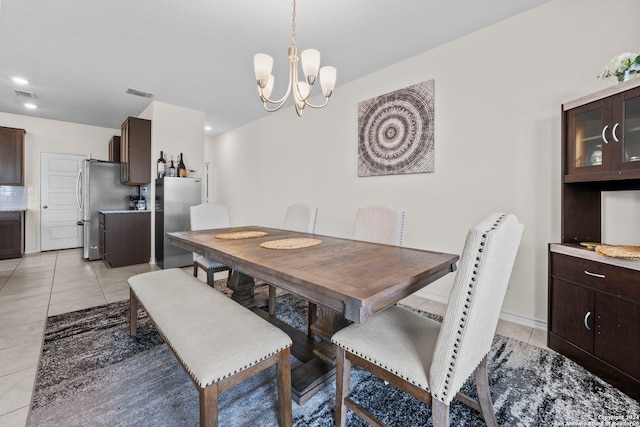 tiled dining space with an inviting chandelier