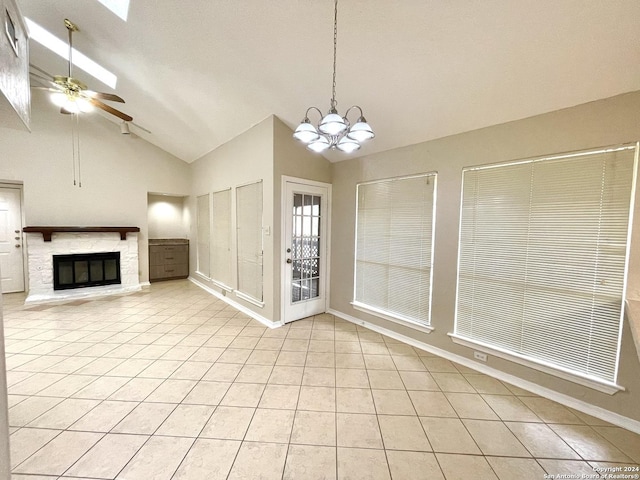 unfurnished living room with a fireplace, light tile patterned floors, ceiling fan with notable chandelier, and high vaulted ceiling