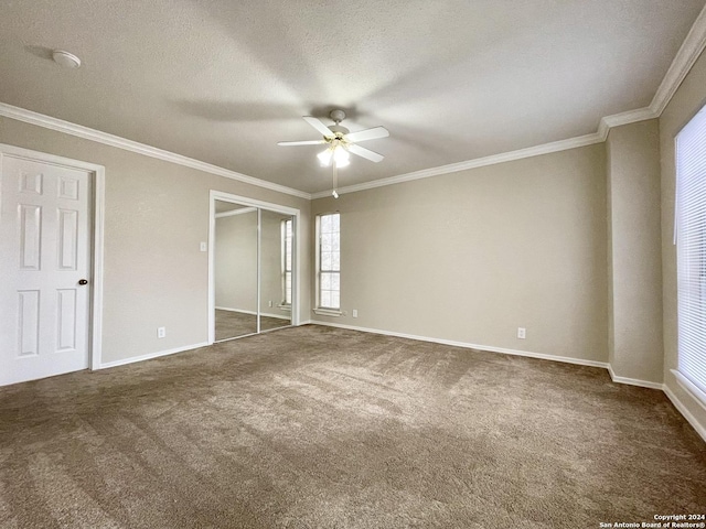 unfurnished bedroom featuring ceiling fan, crown molding, a textured ceiling, and dark colored carpet