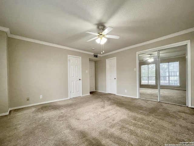 unfurnished bedroom featuring carpet flooring, ceiling fan, crown molding, and a textured ceiling