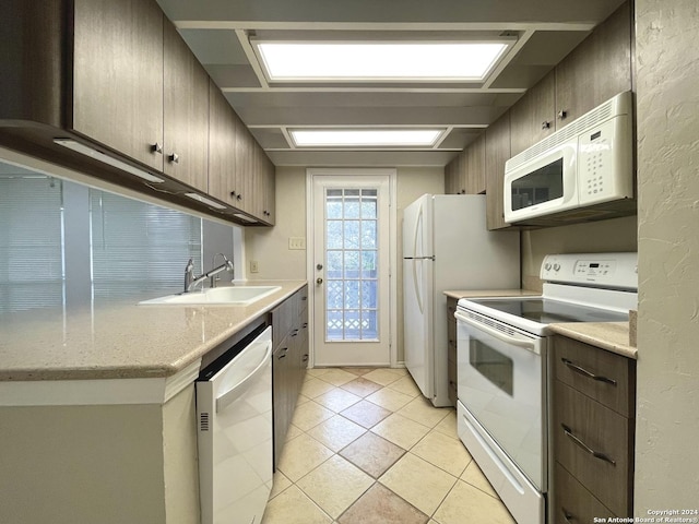 kitchen featuring white appliances, sink, and light tile patterned floors