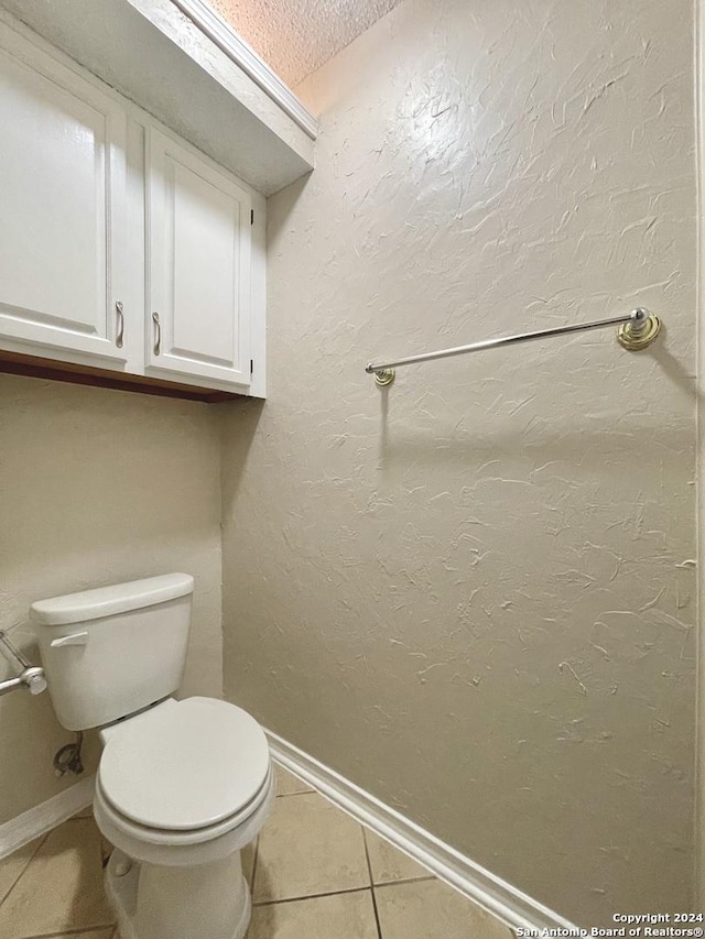 bathroom featuring tile patterned flooring, toilet, and a textured ceiling