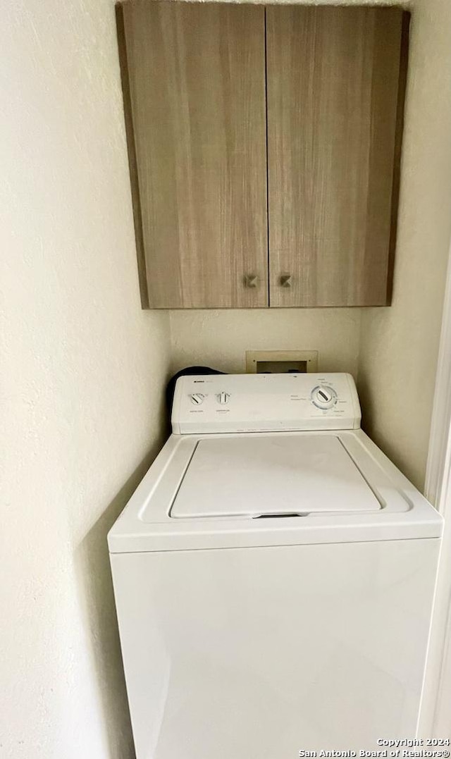 washroom with cabinets and washer / dryer