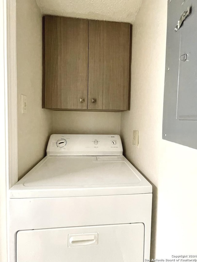 washroom featuring cabinets, washer / dryer, a textured ceiling, and electric panel