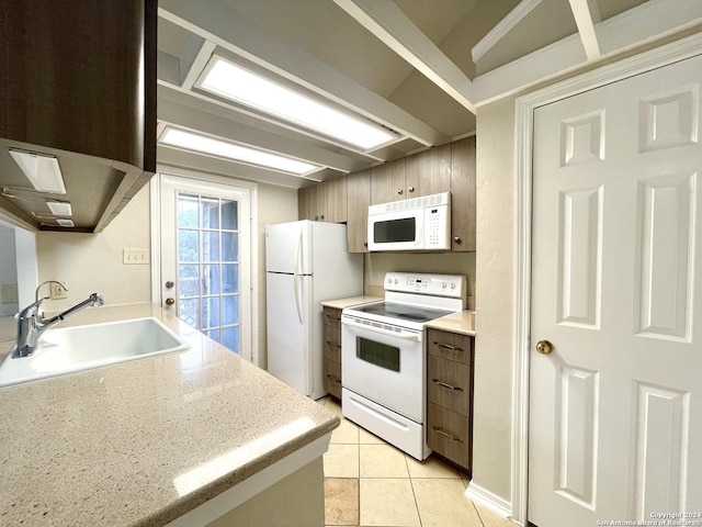 kitchen with light tile patterned floors, white appliances, and sink