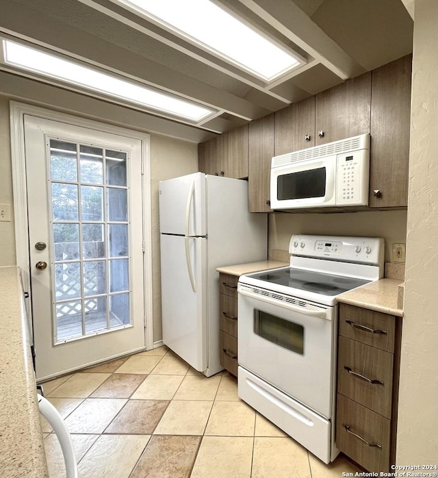 kitchen featuring white appliances and light tile patterned floors