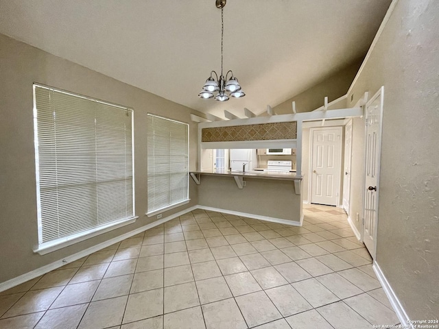 kitchen with kitchen peninsula, a kitchen breakfast bar, light tile patterned floors, decorative light fixtures, and lofted ceiling