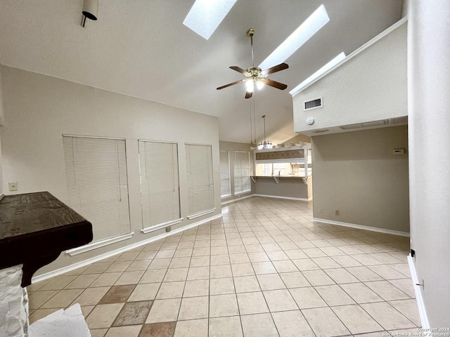 unfurnished living room featuring ceiling fan, light tile patterned floors, high vaulted ceiling, and a skylight