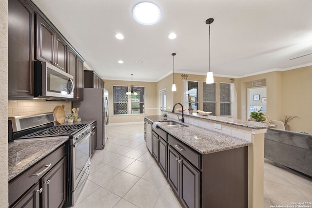 kitchen featuring decorative light fixtures, stainless steel appliances, sink, ornamental molding, and dark brown cabinetry