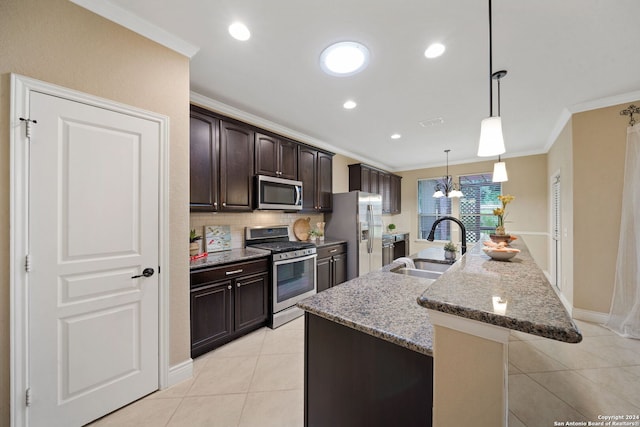 kitchen featuring stainless steel appliances, sink, dark stone counters, dark brown cabinetry, and a center island with sink