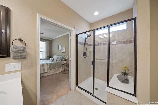 bathroom with tile patterned flooring, a shower with shower door, crown molding, and vanity