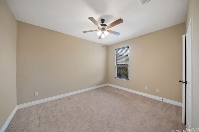 spare room with ceiling fan and light carpet