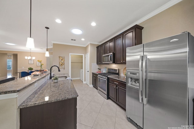 kitchen featuring decorative light fixtures, sink, appliances with stainless steel finishes, dark stone countertops, and dark brown cabinetry