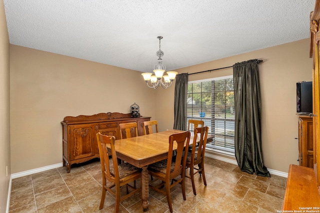 dining area featuring a textured ceiling and an inviting chandelier