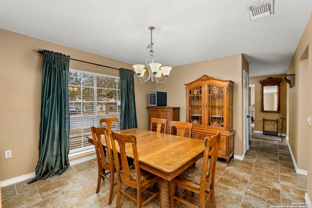 dining space featuring a textured ceiling and a notable chandelier