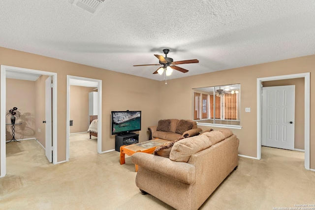 living room with a textured ceiling, light colored carpet, and ceiling fan