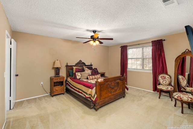 carpeted bedroom with ceiling fan and a textured ceiling