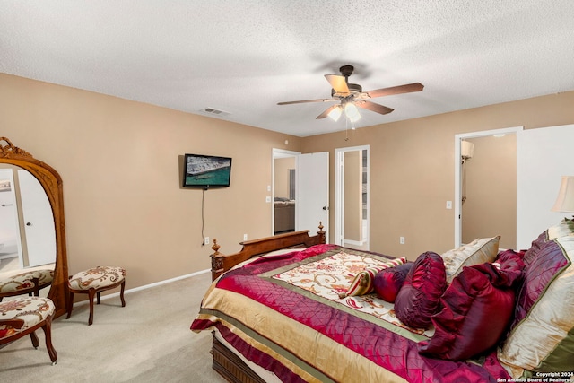 carpeted bedroom featuring ceiling fan and a textured ceiling