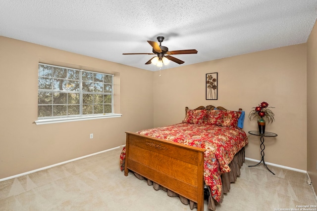 bedroom featuring ceiling fan, light carpet, and a textured ceiling