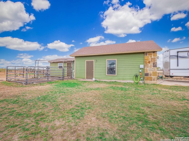 rear view of house featuring a yard