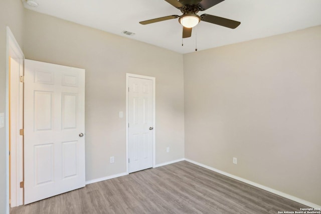 unfurnished bedroom with ceiling fan and hardwood / wood-style flooring