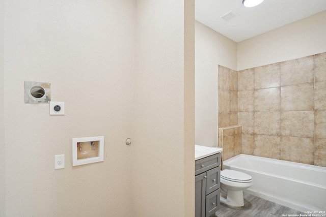 full bathroom featuring vanity, toilet, wood-type flooring, and tiled shower / bath combo