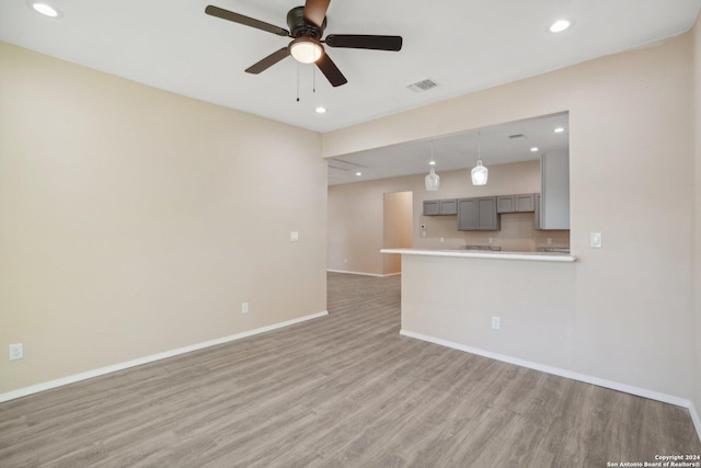 unfurnished living room with hardwood / wood-style flooring and ceiling fan