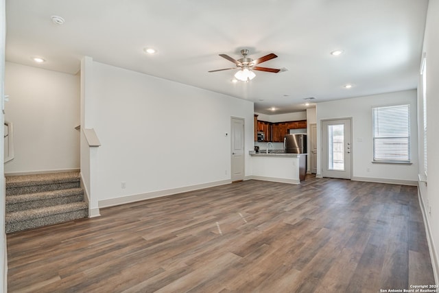 unfurnished living room featuring ceiling fan, dark wood-type flooring, and sink