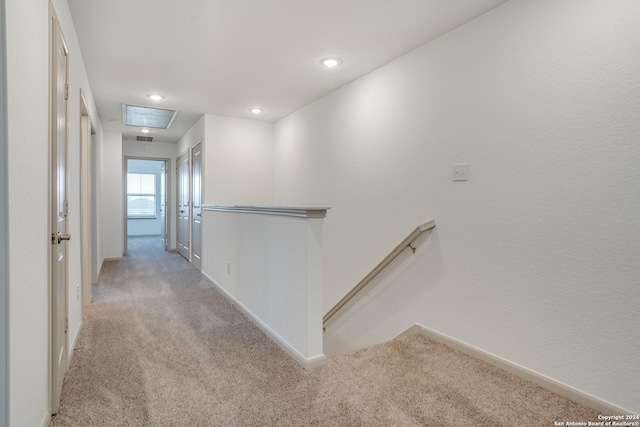 hallway featuring light colored carpet