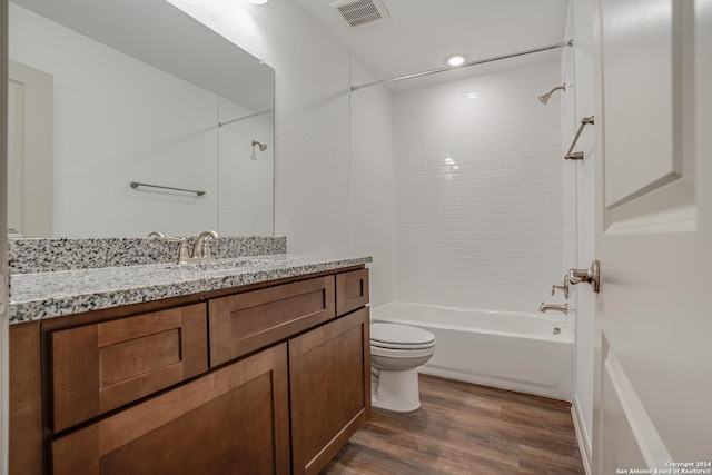 full bathroom with hardwood / wood-style floors, vanity, toilet, and tiled shower / bath combo