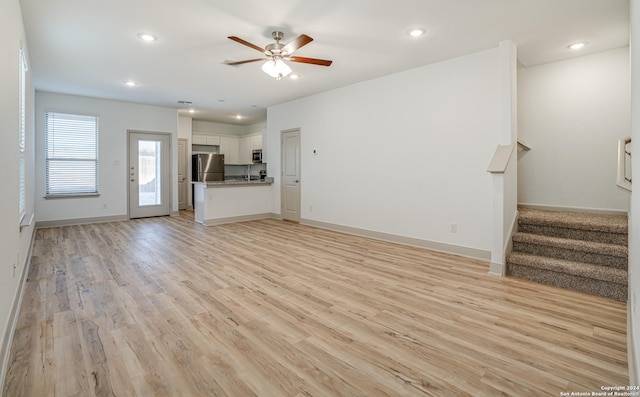 unfurnished living room with light hardwood / wood-style floors and ceiling fan