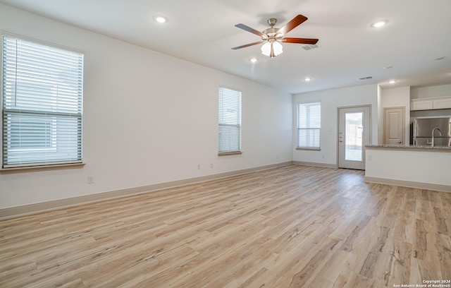 unfurnished living room with ceiling fan and light hardwood / wood-style flooring