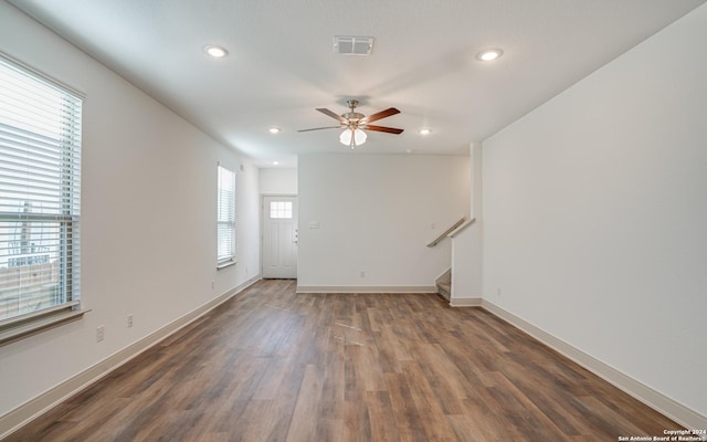 unfurnished room with dark hardwood / wood-style floors, ceiling fan, and a healthy amount of sunlight