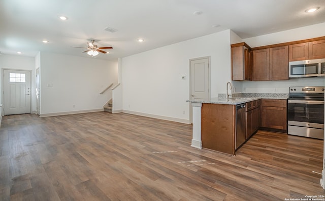 kitchen with light stone countertops, sink, dark wood-type flooring, and appliances with stainless steel finishes