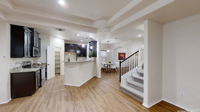 kitchen featuring stainless steel appliances, light stone counters, and light hardwood / wood-style floors