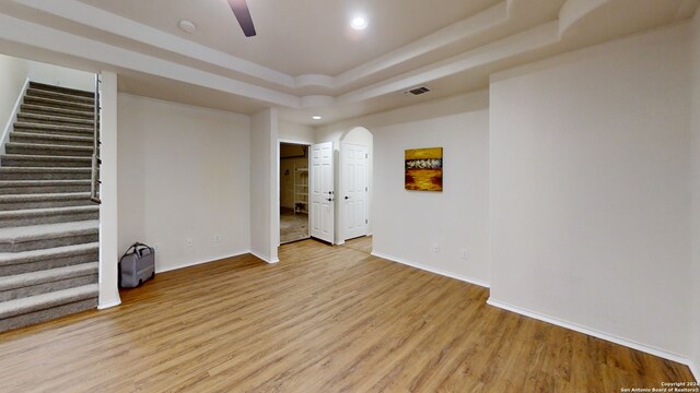 spare room featuring a raised ceiling and light hardwood / wood-style floors