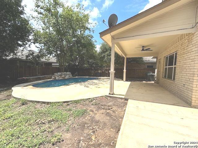 view of yard with a fenced in pool, ceiling fan, and a patio