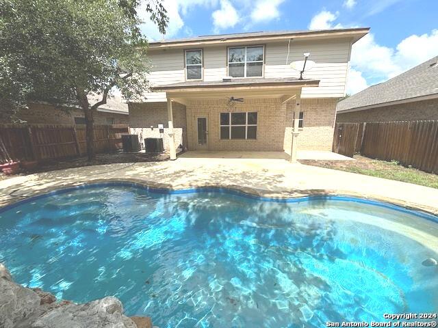 view of pool featuring central air condition unit, a patio area, and ceiling fan