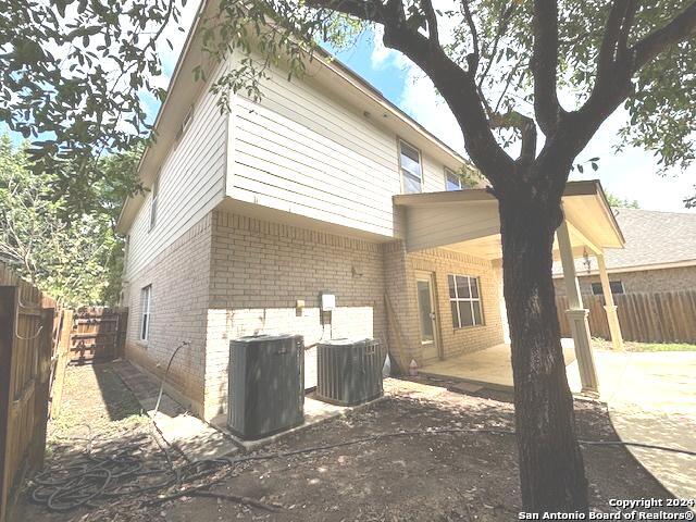 back of property with central AC and a patio area