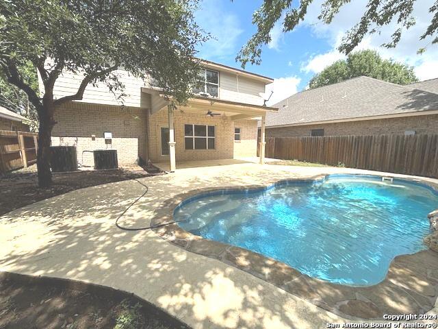 view of pool with ceiling fan, a patio, and central AC unit