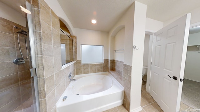 bathroom featuring tile patterned floors, toilet, and independent shower and bath