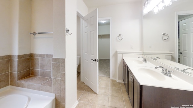 bathroom featuring tile patterned floors, a washtub, vanity, and toilet