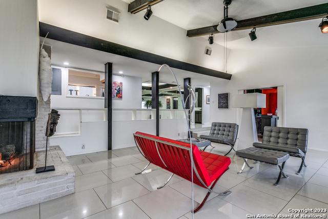 tiled living room with beam ceiling