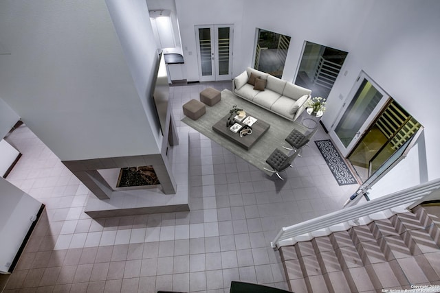 tiled living room with a towering ceiling