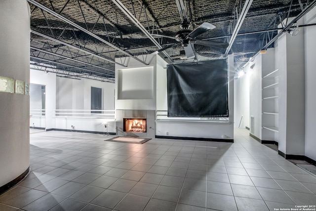 unfurnished living room featuring tile patterned flooring, a high ceiling, and ceiling fan