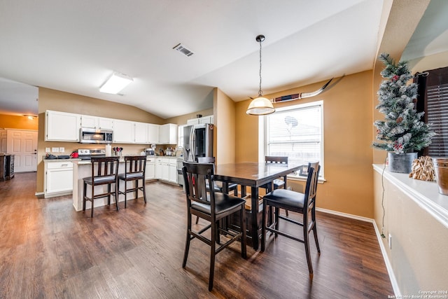 dining space featuring dark wood-type flooring and vaulted ceiling