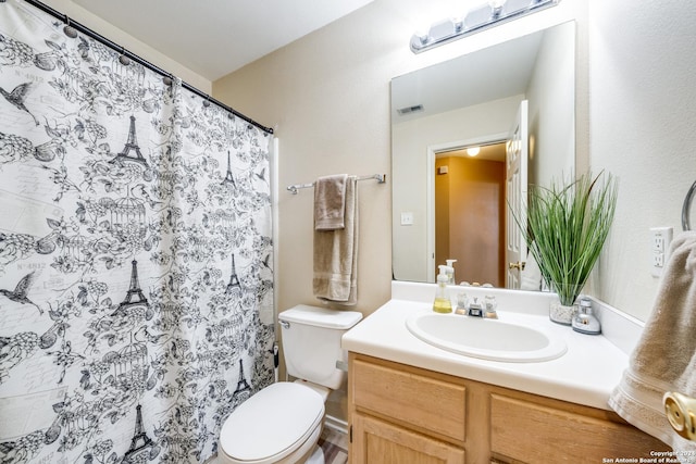 bathroom featuring vanity, toilet, and walk in shower